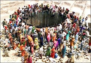 Women of Gujarat State, India, throng a well.