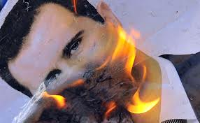 Bashir al-Assad poster in flames.