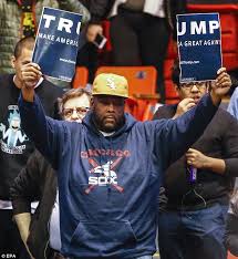 TrumpSignRippedinTwoBlackProtester