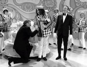 Tiny Tim successfully hand-shake crushes John Wayne on Laugh-in. All in good fun as we "tip toe through the tulips" in falsetto voice like he used to sing it with his Cooky Ukulele.